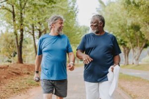 two-older-adult-men-jogging-in-park-sunny-day