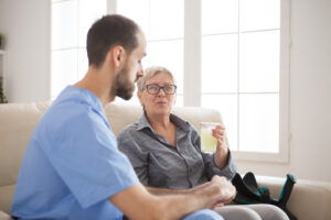 Older woman on couch with home nurse